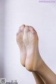 A close up of a woman's bare feet on a white background.