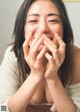 A woman covering her mouth with her hands.