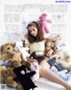 A woman sitting on top of a pile of teddy bears.