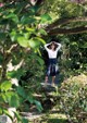 A woman standing in the middle of a lush green forest.