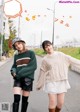 A couple of women standing next to each other on a street.