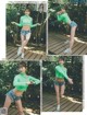 A woman in a green top and denim shorts posing for a picture.