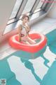 A woman in a bathing suit sitting on an inflatable ring in a swimming pool.